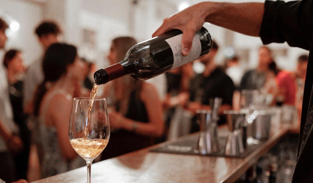 barman pouring wine in glass